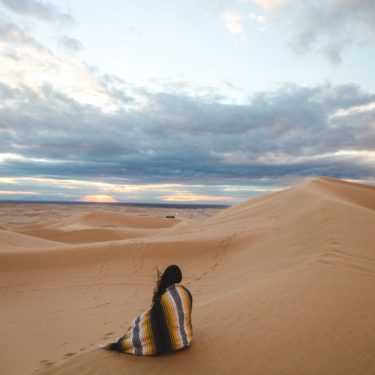 woman sitting in the desert